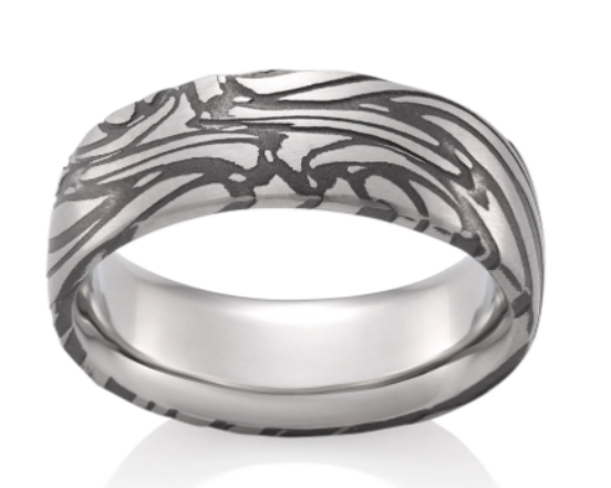 A silver-toned band ring featuring a matte outer surface with an intricate, dark gray abstract wave or flame-like pattern, shown on a clean white background with a soft reflection.